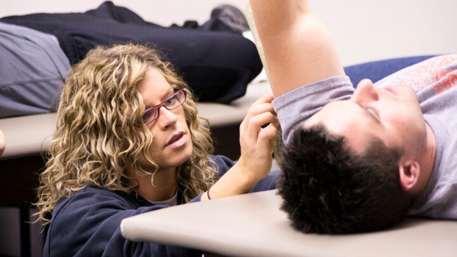 a female physical therapist assistant helps a patient