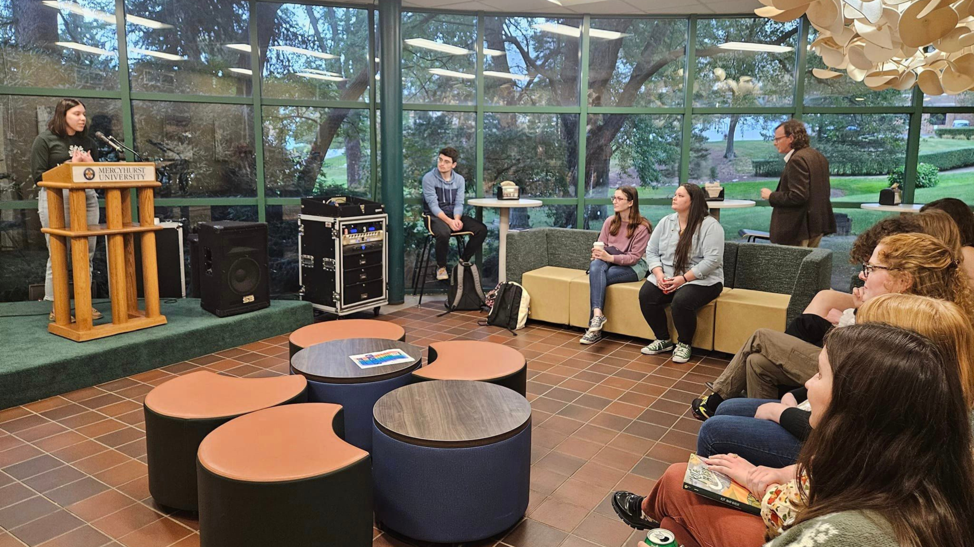 a group of English majors and professors gather for an open mic night