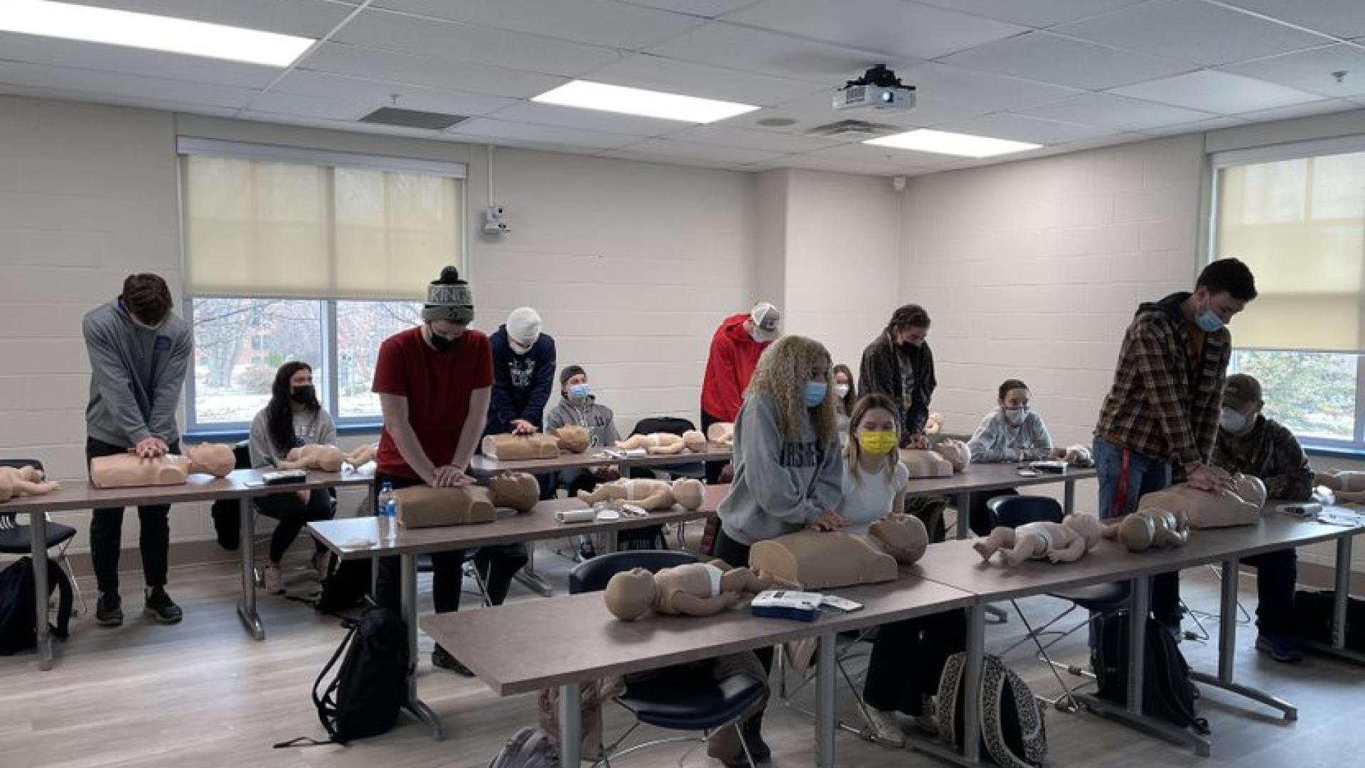 Students practice CPR on dummies