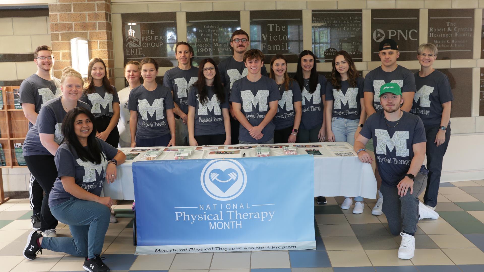 class posing with physical therapy outreach table