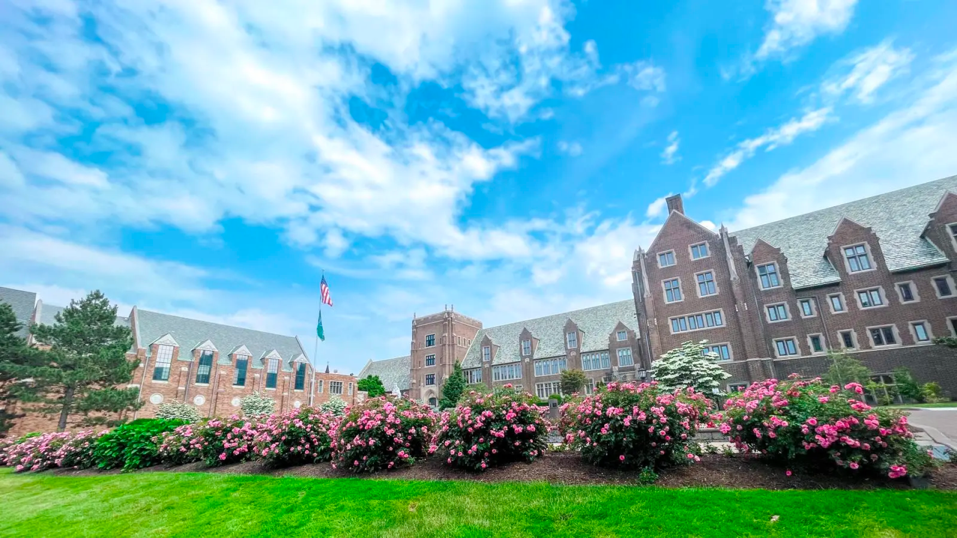 Exterior of Old Main on campus with flowers blooming