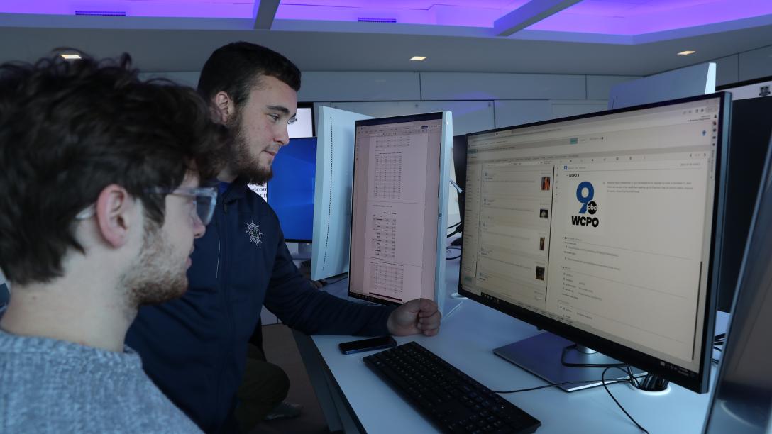 two male students work together in cyber lab