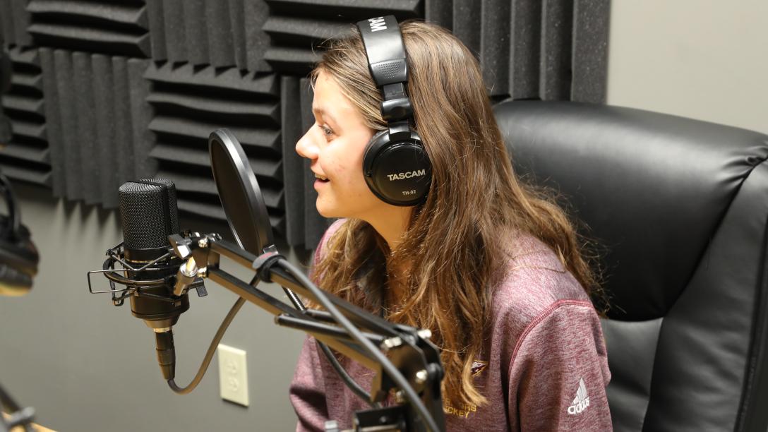a female student records a podcast