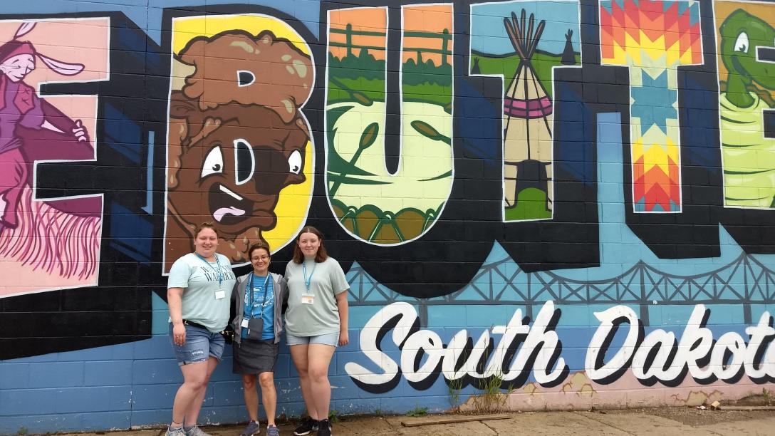 three female art program graduates pose for a photo in South Dakota