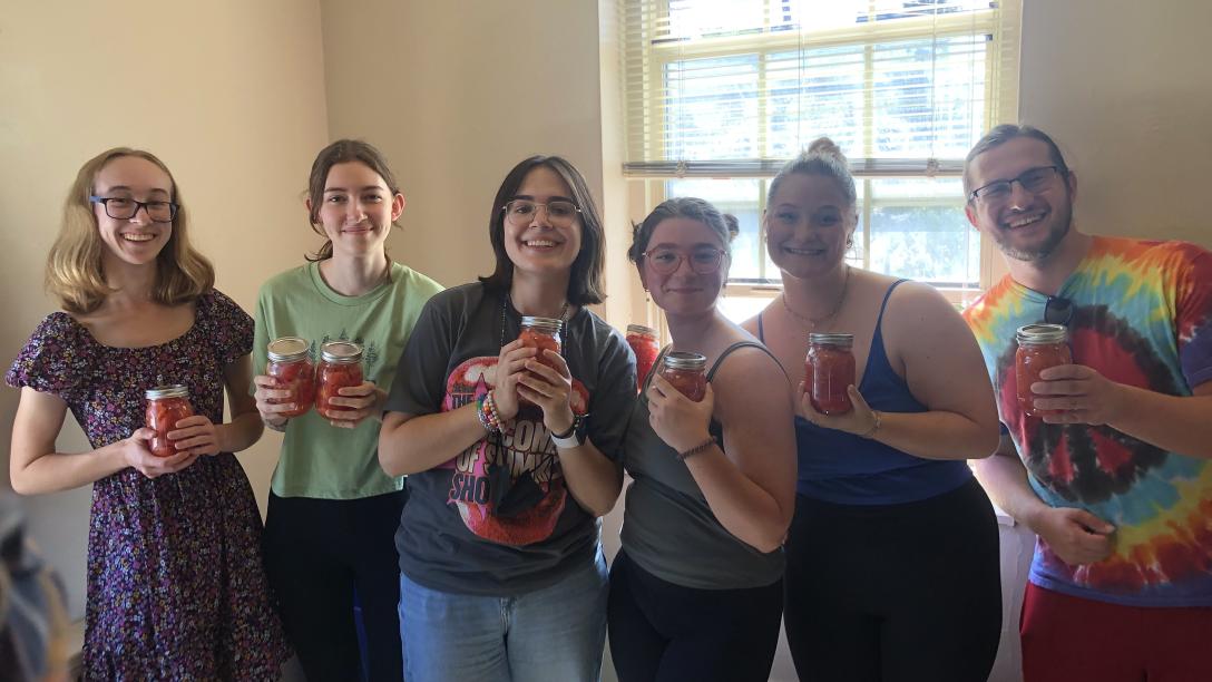 Students posing with jars during a canning event