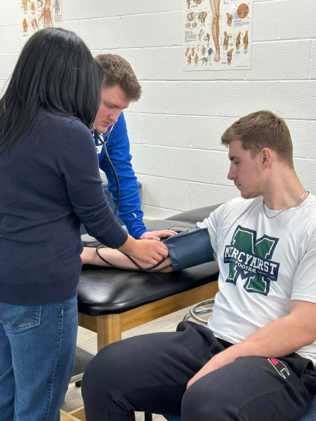 physical therapist assistants check a male student's blood pressure