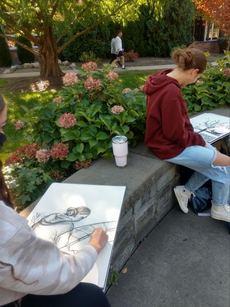 two female art students sketching outside